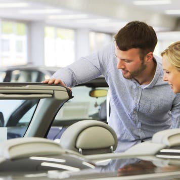 Couple looks at a car at a dealership