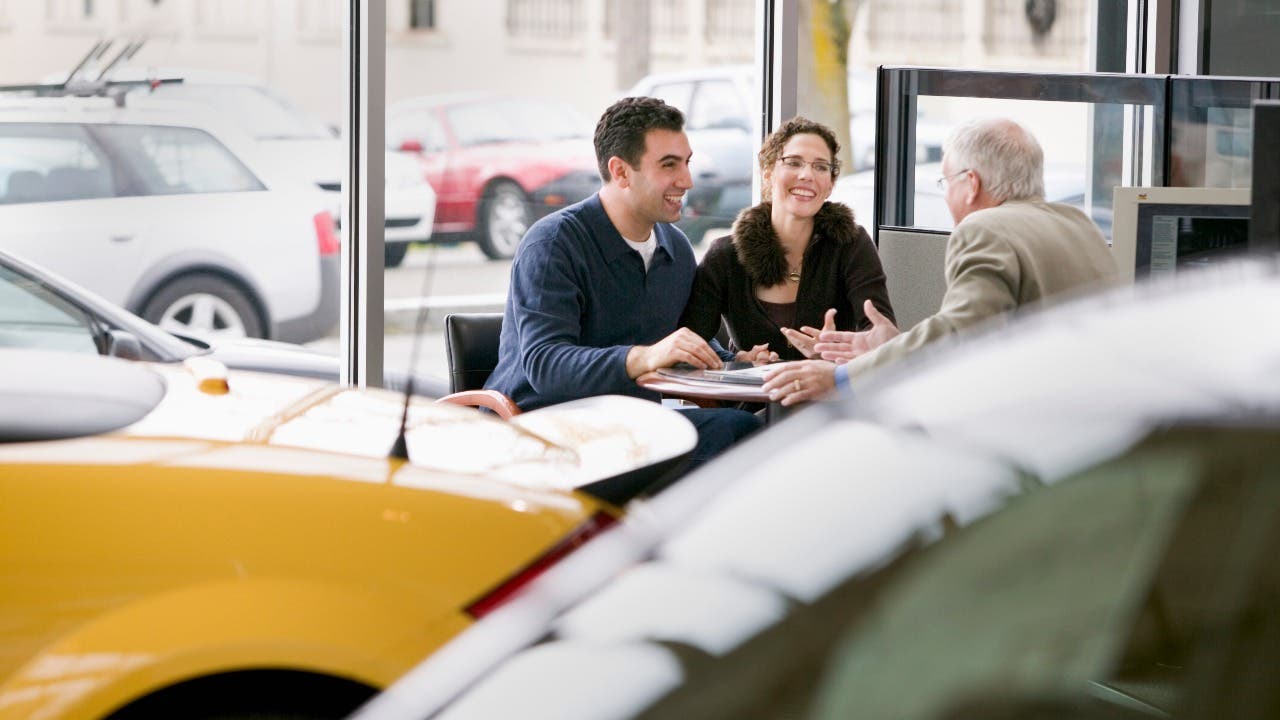 Couple negotiates at an auto dealership