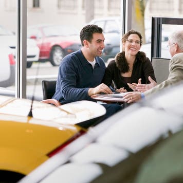Couple negotiates at an auto dealership
