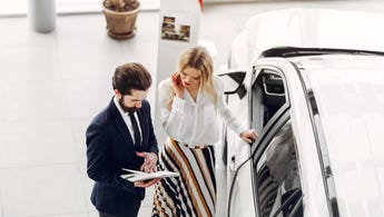 A salesperson and a customer discuss a car
