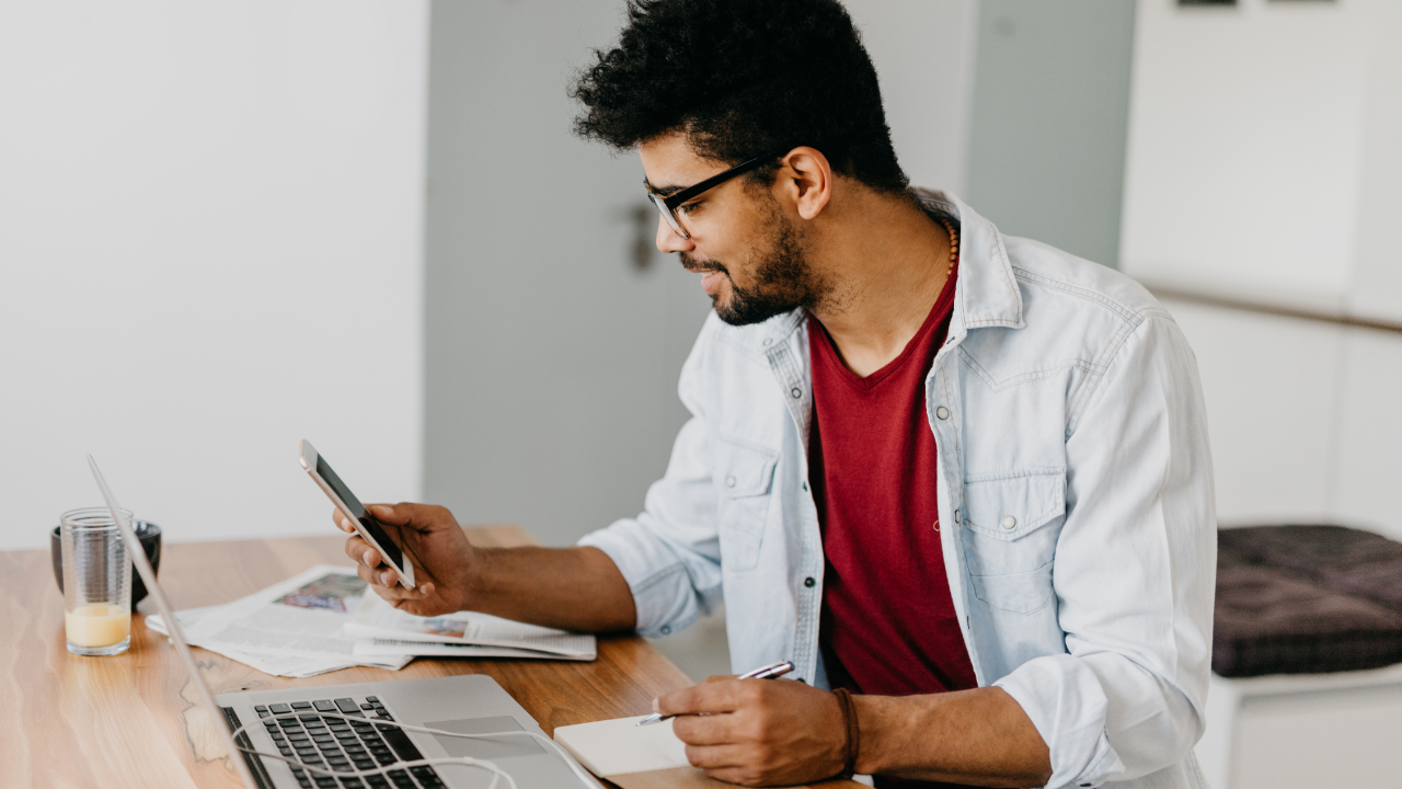 Man sitting at the desk and paying bills with his credit card online using laptop.