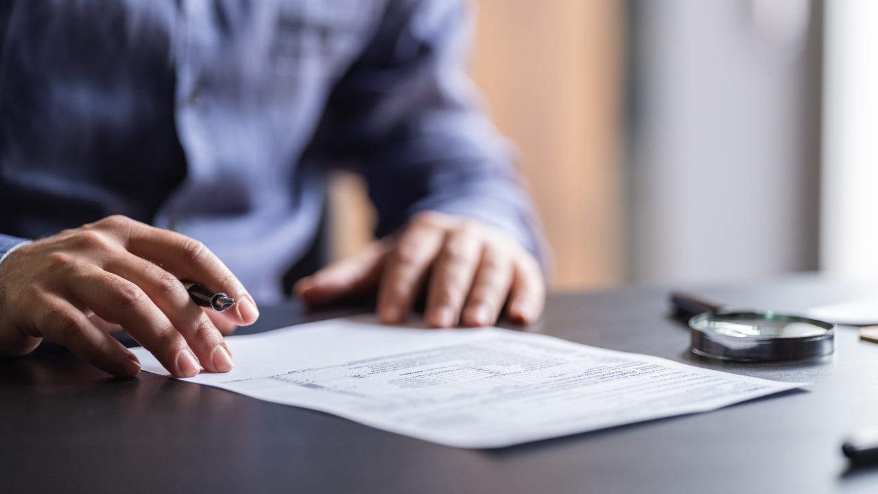 Man sitting at table filling out tax form