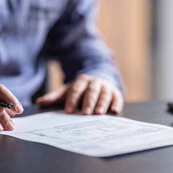 Man sitting at table filling out tax form