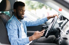 Man checks phone while sitting in car