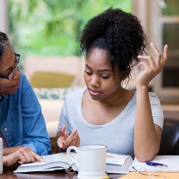 Mother and college student look at textbooks
