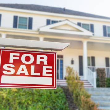 For Sale Real Estate Sign in Front of New House.