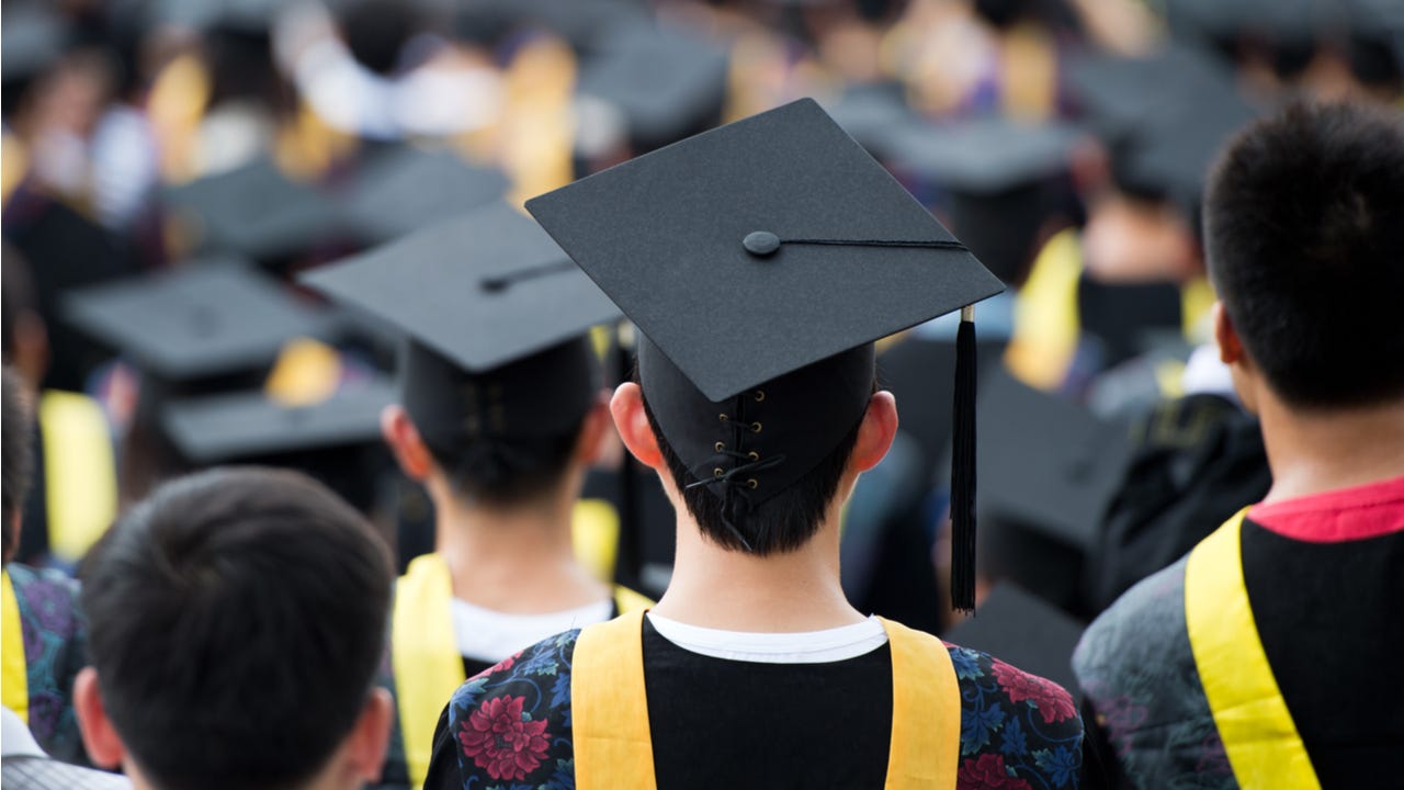 College graduates stand at graduation