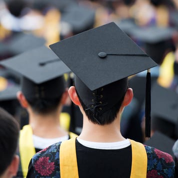 College graduates stand at graduation