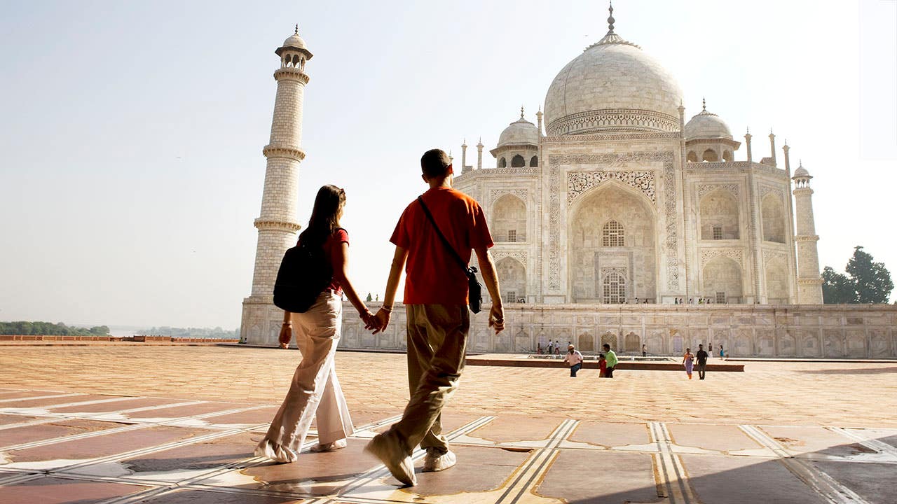 Young couple walking in the Taj Mahal courtyard