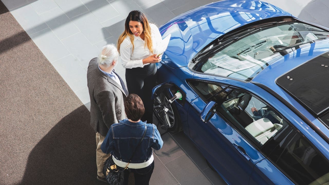 Couple looks at a car at a car dealership