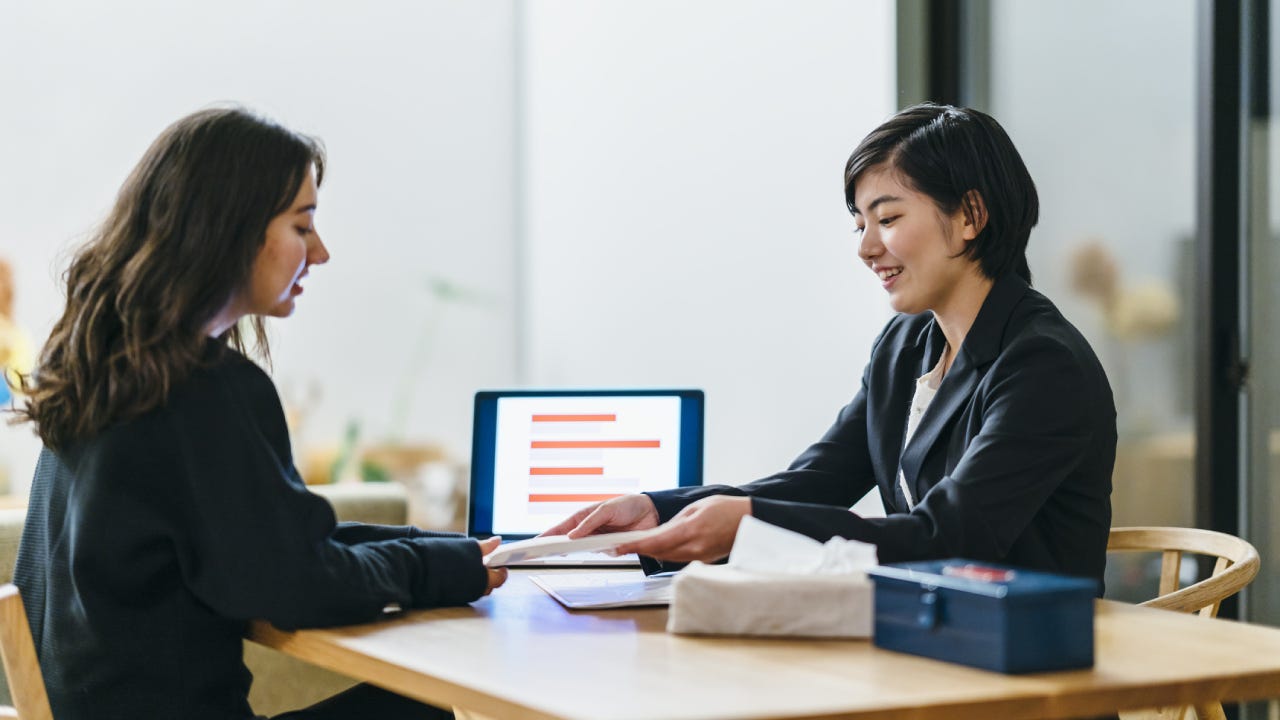 An Asian financial advisor goes over some things with a client.