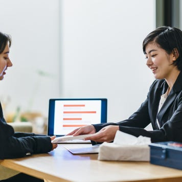 An Asian financial advisor goes over some things with a client.