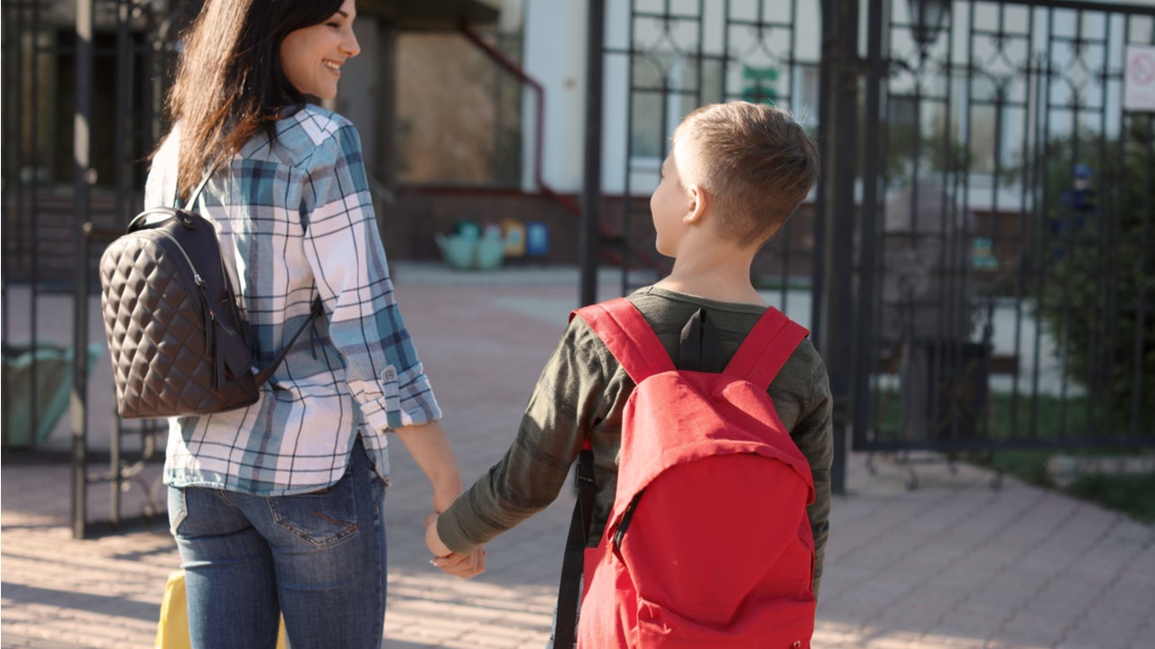 Mother walks a child to first day of school