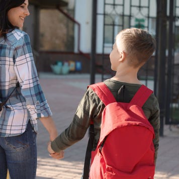 Mother walks a child to first day of school