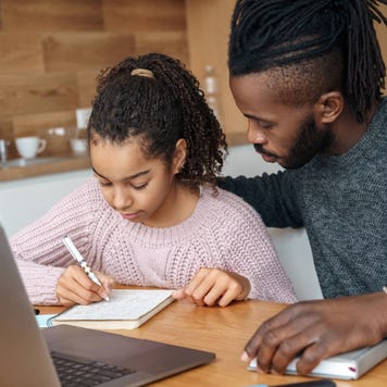 Father helps daughter with homework