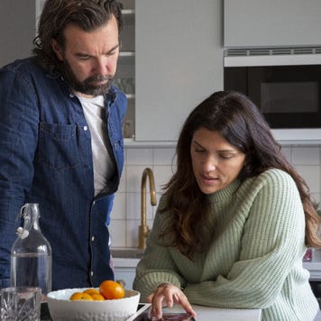 Man and woman at kitchen island looking at mobile phone