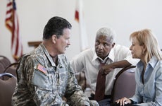 A military veteran discusses financing and insurance options with some experts.