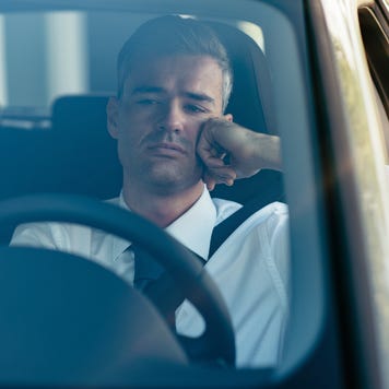 Close up front view of businessman in driver's seat with pensive expression