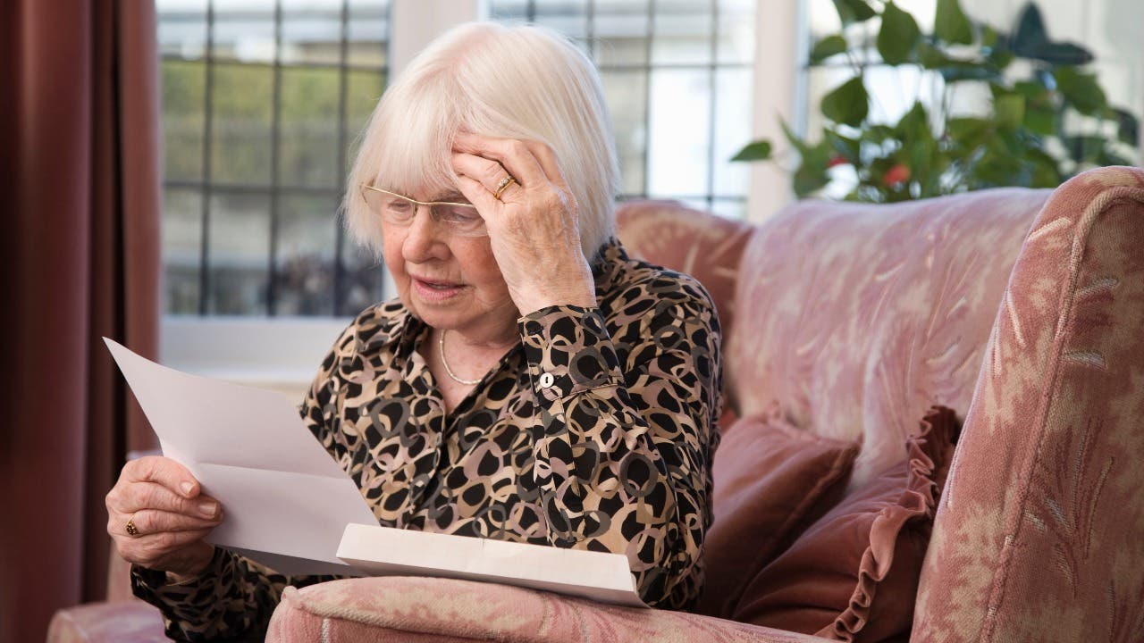 Woman looks at paperwork with concern