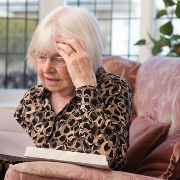Woman looks at paperwork with concern