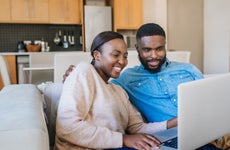 Young couple work together on laptop in apartment