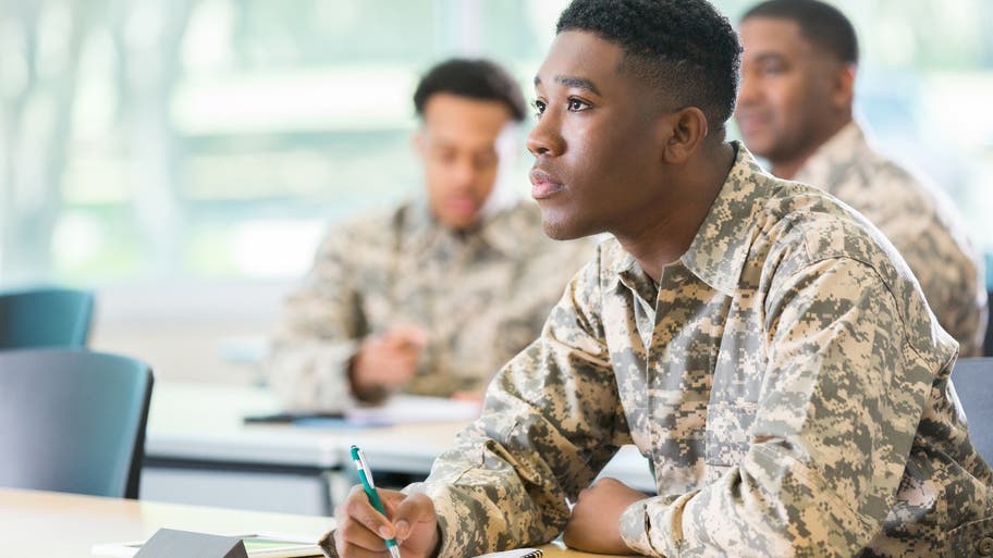 Veteran college student takes notes in class