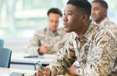Veteran college student takes notes in class