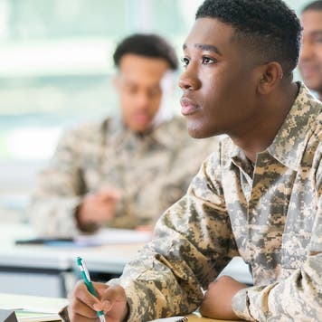 Veteran college student takes notes in class