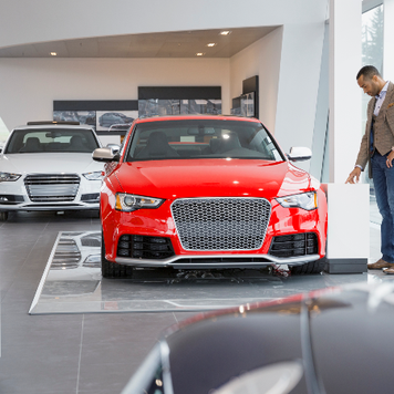 man looking at new car at dealership