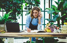 Florist works on paperwork while on the phone