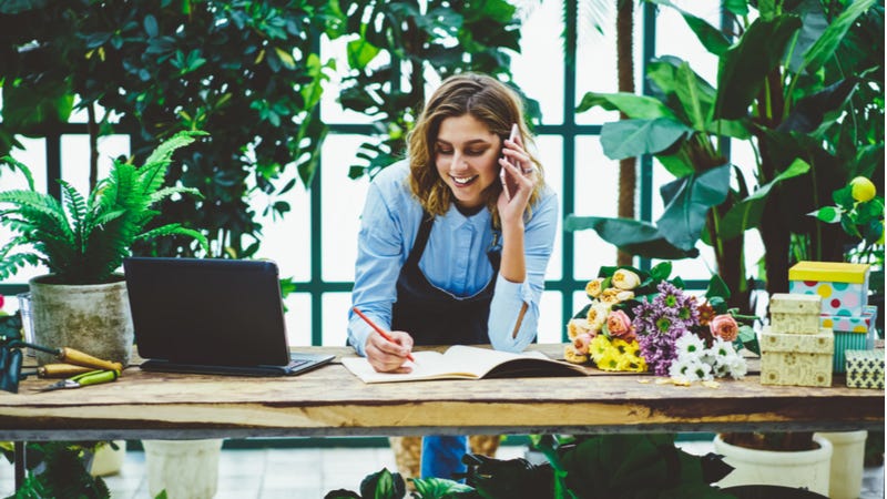 Florist works on paperwork while on the phone