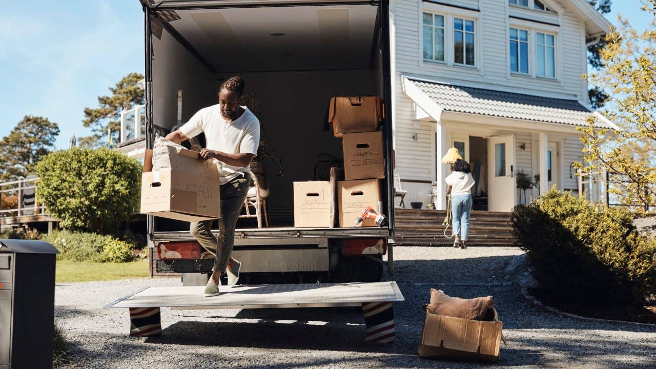 Man removing cardboard boxes from a van