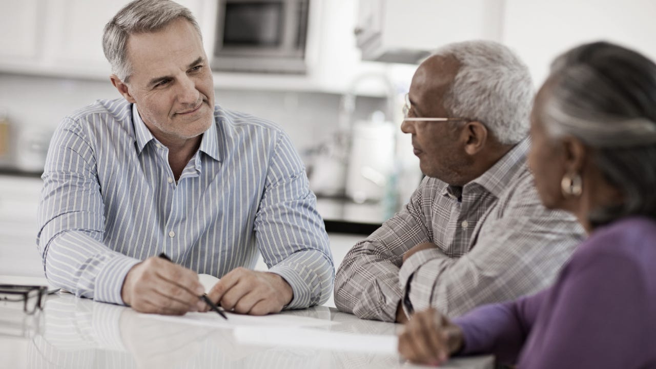 A financial advisor sitting down with an older couple.