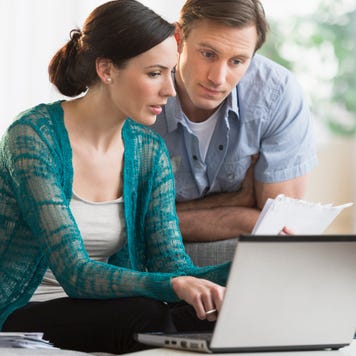 A couple uses a laptop together.