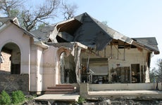 The remains of a home after a natural disaster has swept through and destroyed the roof.