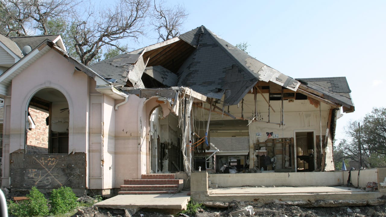The remains of a home after a natural disaster has swept through and destroyed the roof.