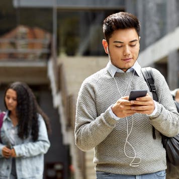 College student looks at phone on campus