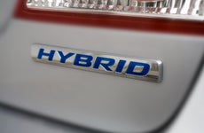 Close-up of the back of a car and its 'hybrid' logo under the taillight