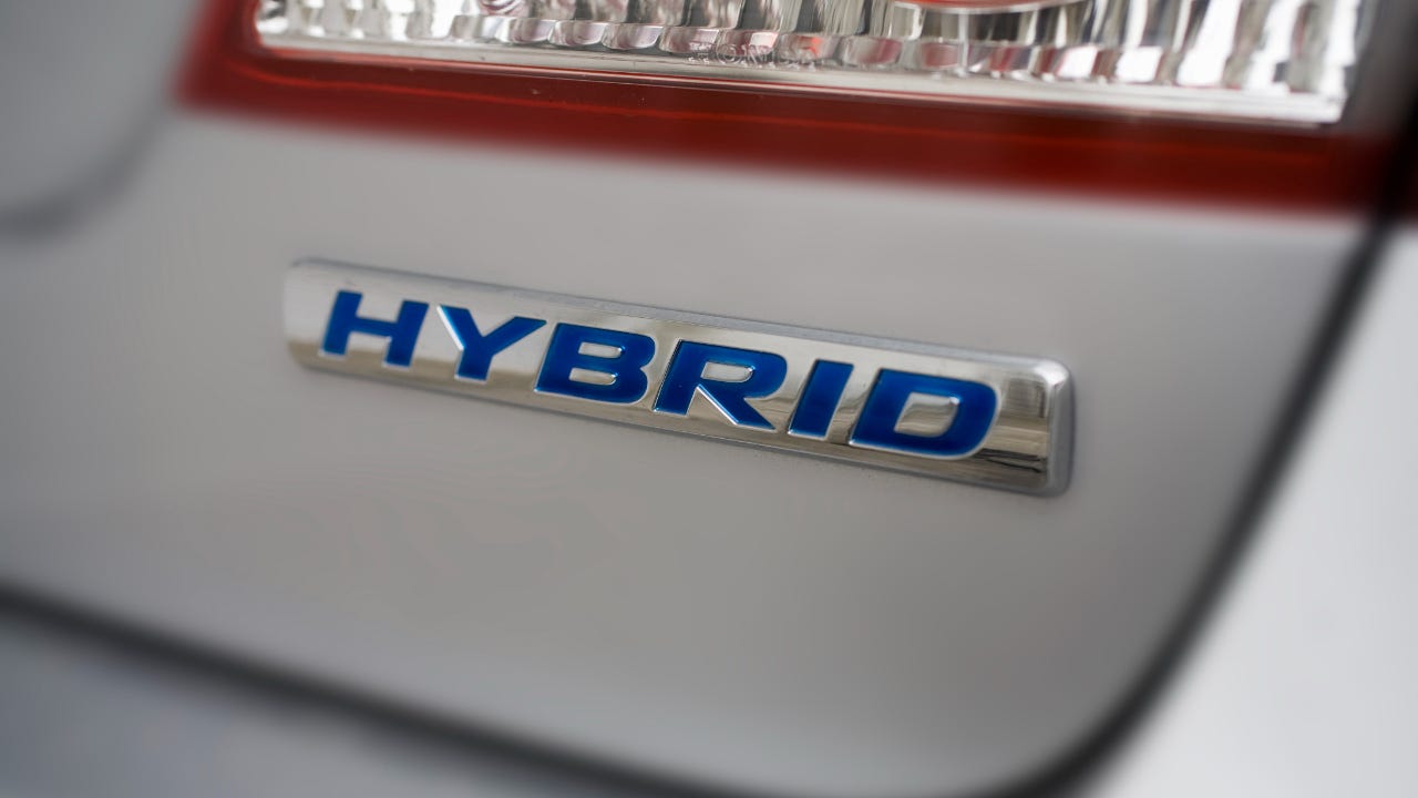 Close-up of the back of a car and its 'hybrid' logo under the taillight