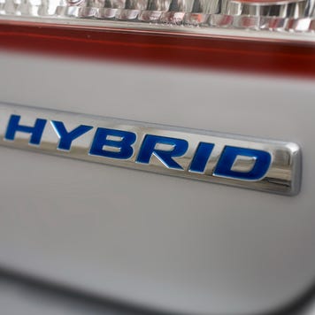 Close-up of the back of a car and its 'hybrid' logo under the taillight