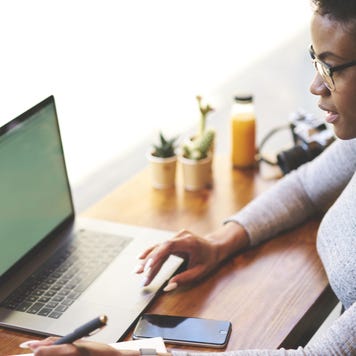 Woman works on laptop at a cafe