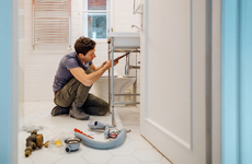 man working on plumbing in home
