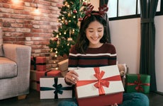 Young Asian woman opens Christmas gift box