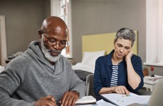 Older interracial couple sitting together at a desk and reviewing their options financially.