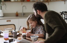 Father and daughter have breakfast in a kitchen