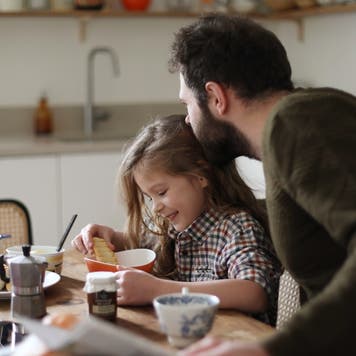 Father and daughter have breakfast in a kitchen