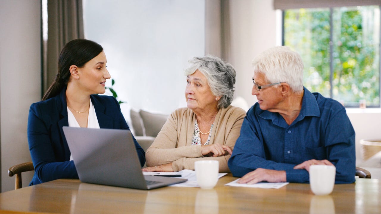 An older couple sits with a young woman who is a financial specialist. She is reviewing their options.