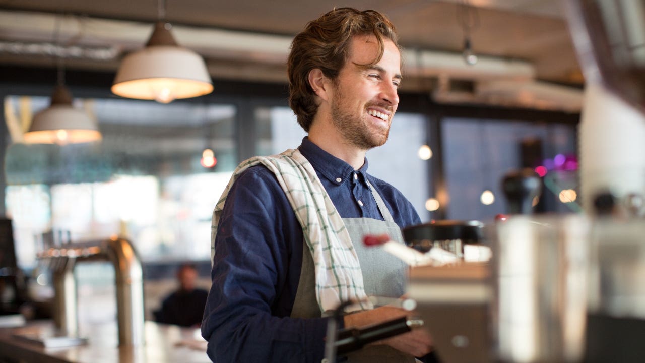 Coffee shop worker smiles at customer