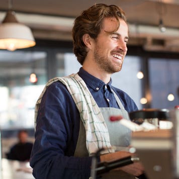 Coffee shop worker smiles at customer