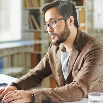 Somber businessman working on laptop